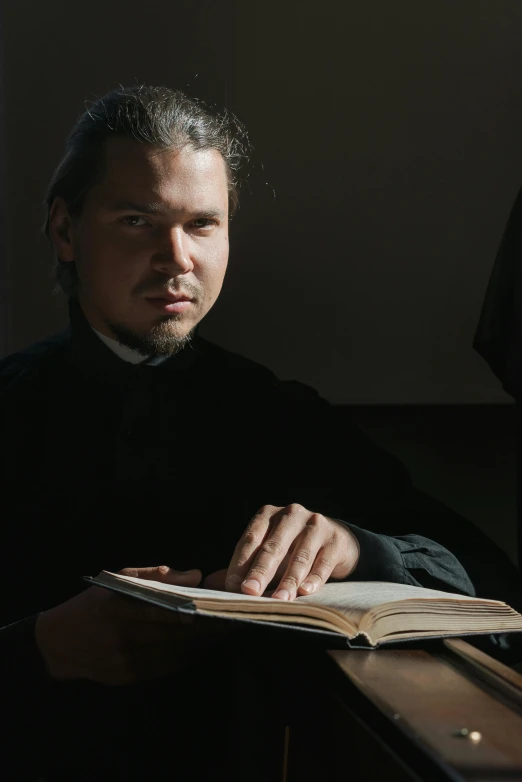 a man sitting down looking at a book