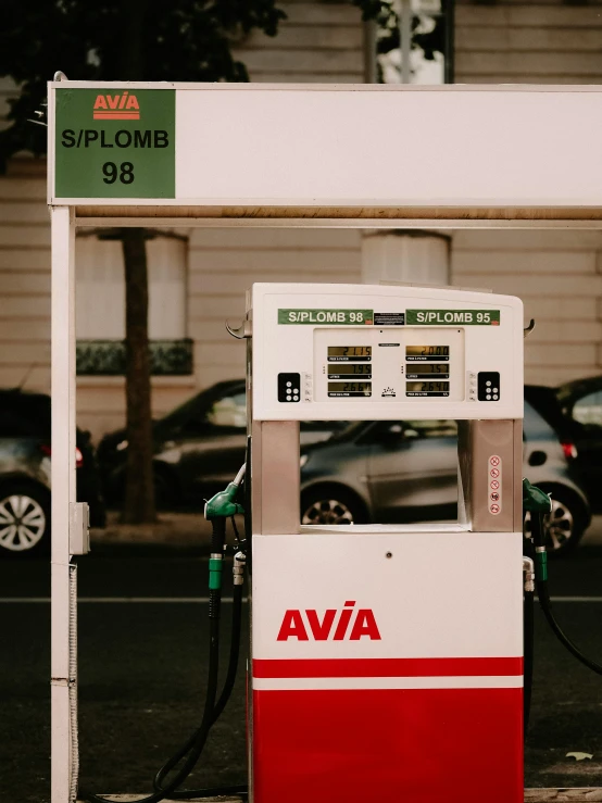 a gas station with two cars parked near it