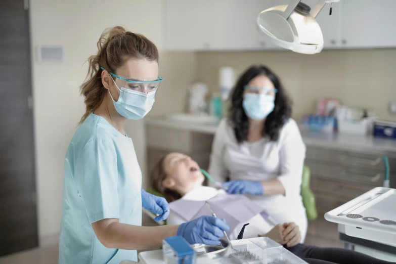 a dentist with her hands over the mouth is preparing to open an open medical folder