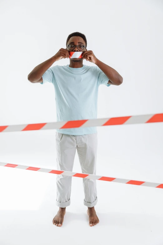 man making a gesture over his eye with orange and white striped caution