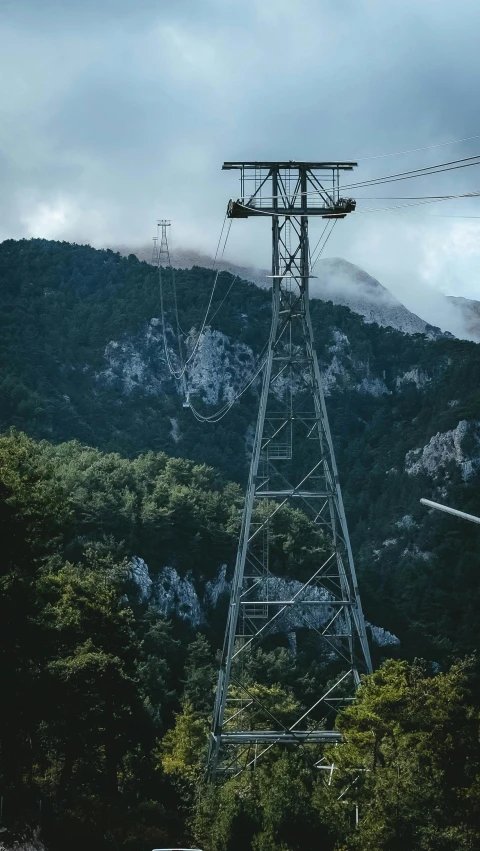 a tall metal tower sitting near the mountains