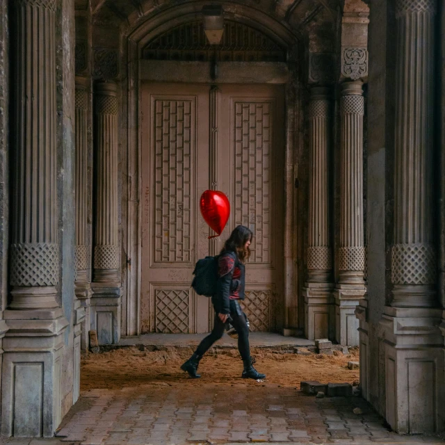 a person is walking through a hallway with a red balloon in their hand