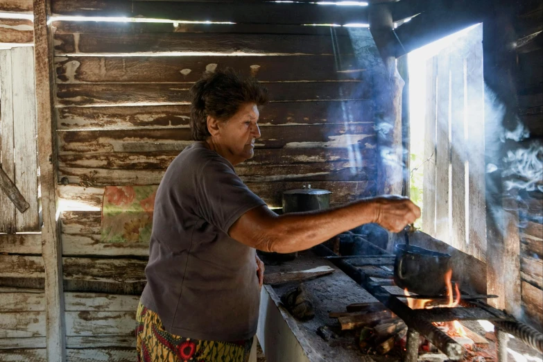 the man is cooking outside in his cabin