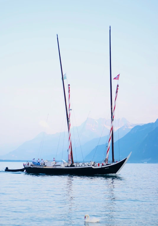 two sail boats are anchored at the ocean