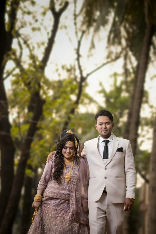 a man and woman dressed in indian clothes stand next to each other