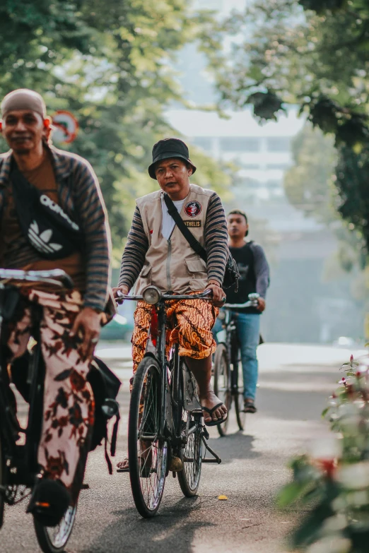 two elderly men on bicycles with a woman nearby