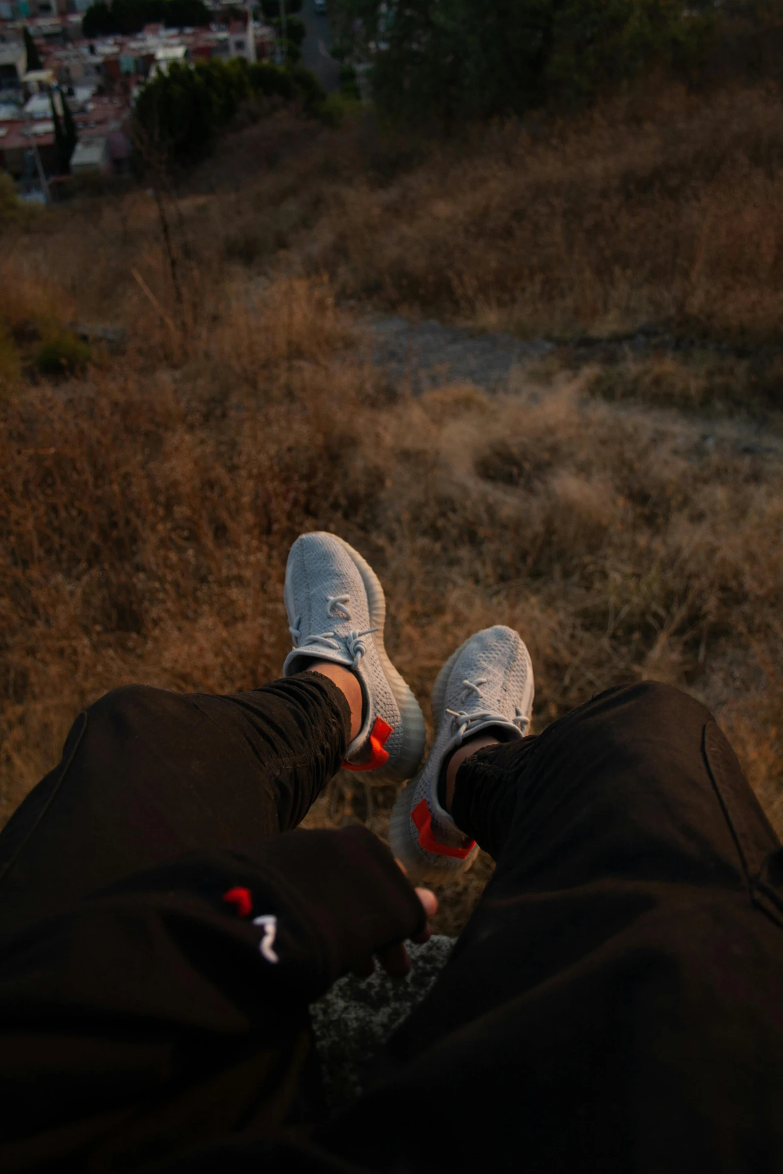 someone's feet in the air from above in front of a field