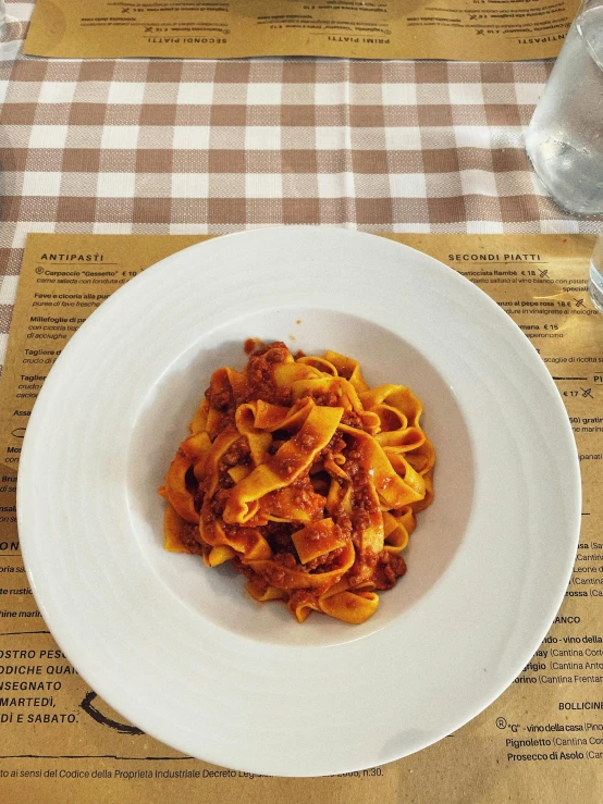 pasta on a white plate sitting on a table