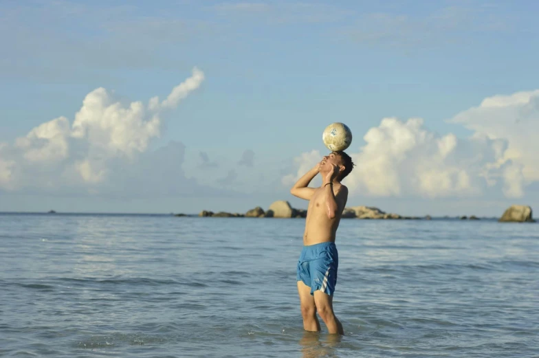 a man standing in water with a white frisbee on his head