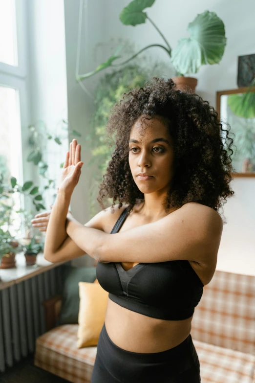 woman stretching in front of a window in a  top and shorts