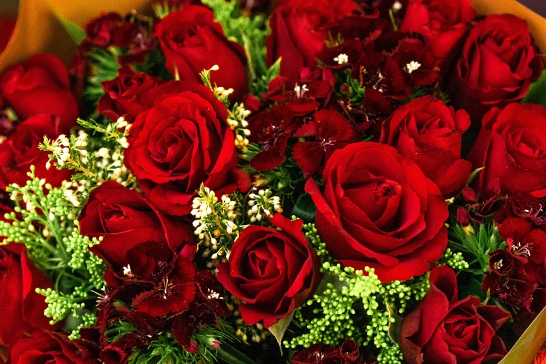 a bouquet of red roses sits in a vase