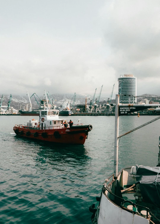 large tug boat approaching a smaller ship in the water