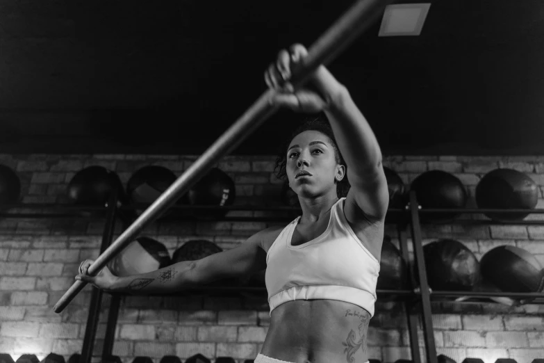 a woman holding up a large bar in a gym