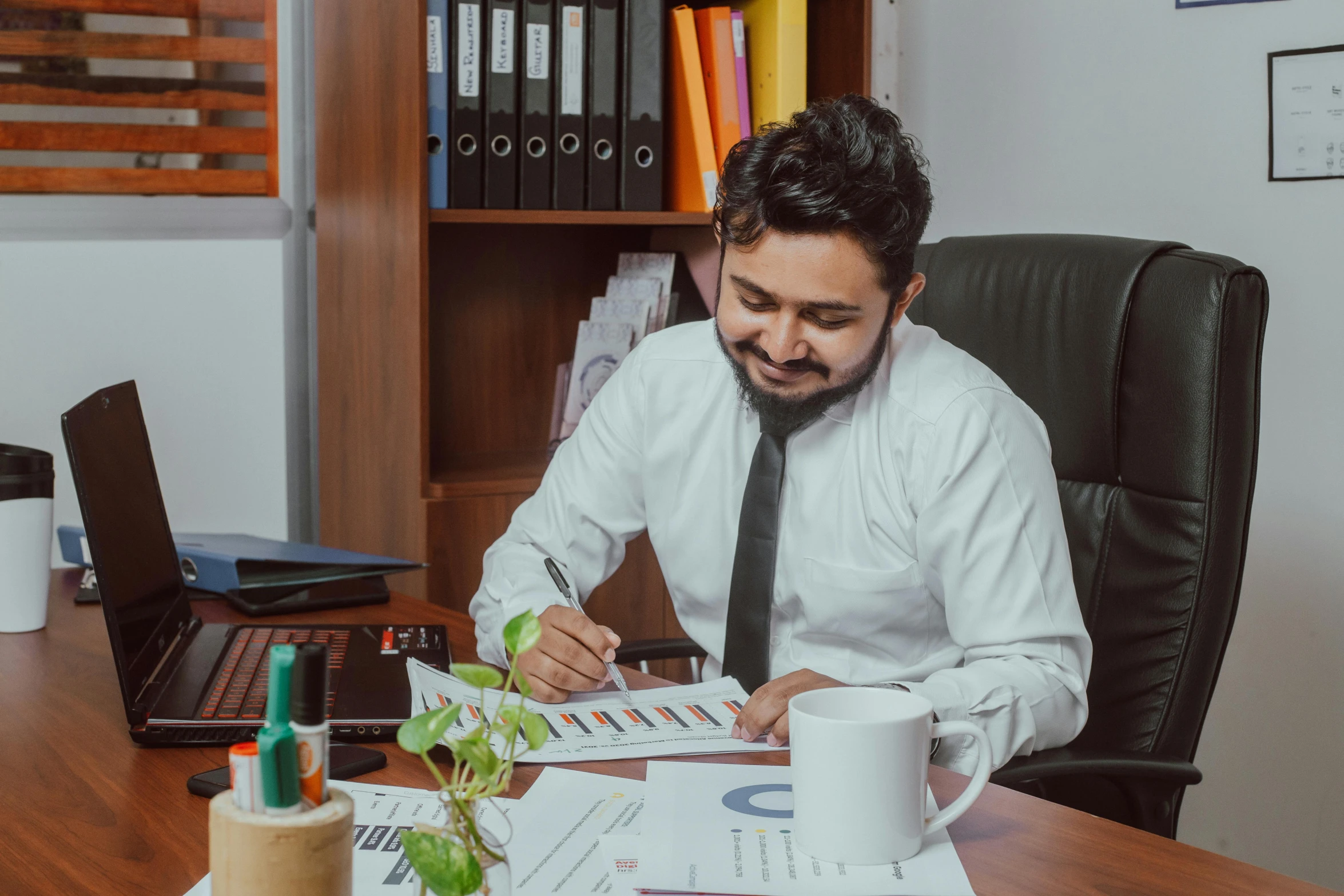 a man wearing a tie and sitting at a desk