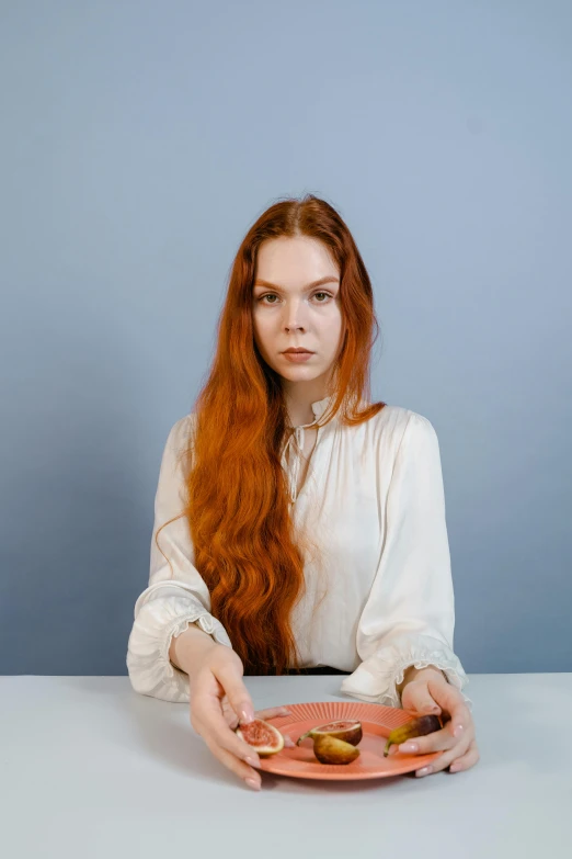 the young woman is holding her plate with two small apples