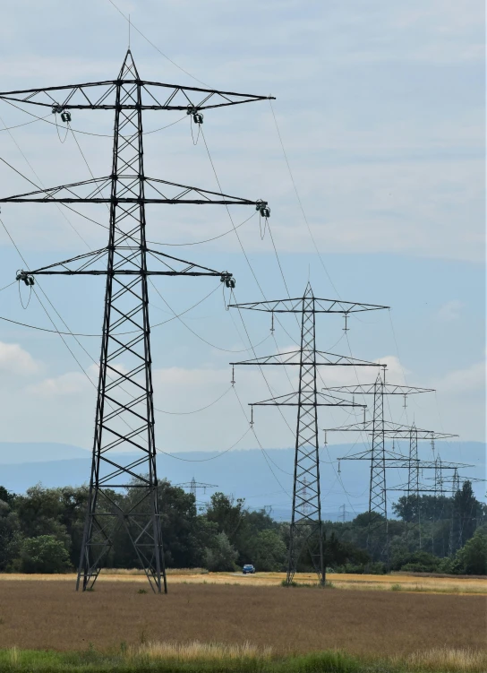 electrical poles in an open field near a city