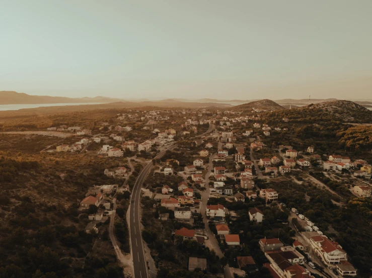 a city with hills in the background and a body of water next to it