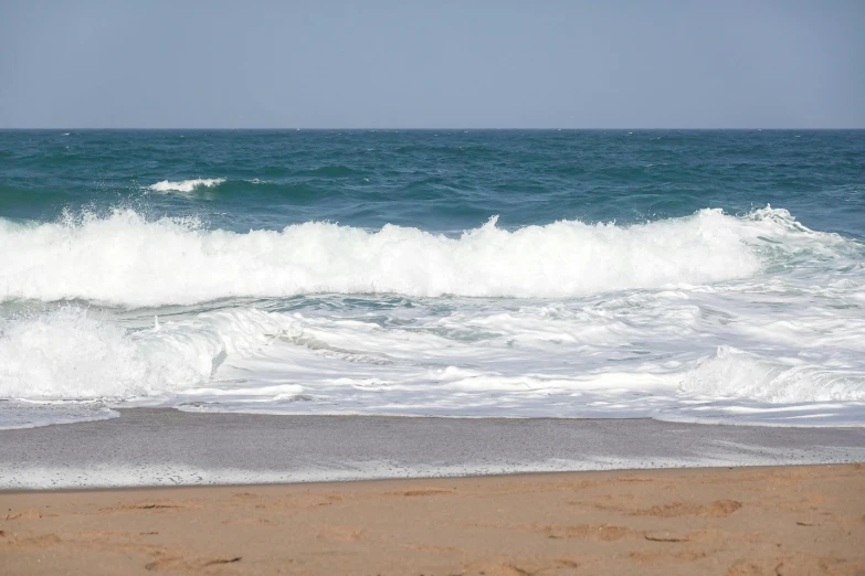 a surf board sits on the beach near the ocean