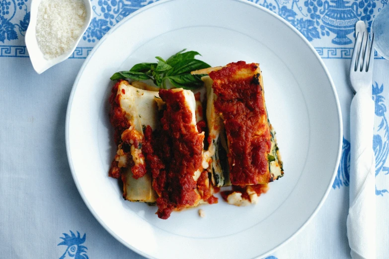 a white plate topped with enchiladas and cheese