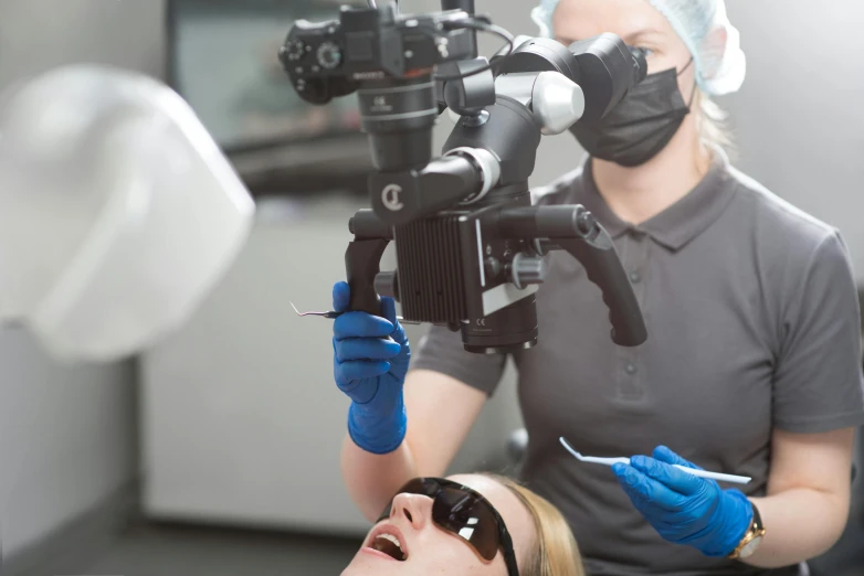 a woman sitting in front of a camera getting her teeth checked