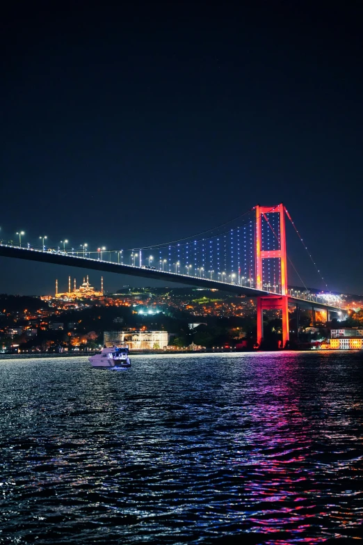 a river with a red bridge and a city behind it