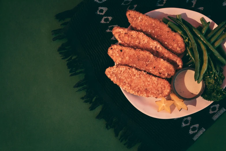 a plate filled with fried meat and green beans