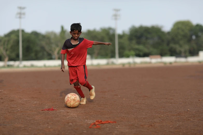 a young soccer player kicking the ball down the field