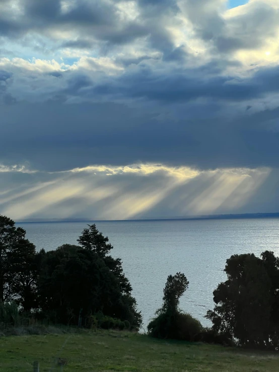 the light beams from behind of a cloudy sky glows into the water