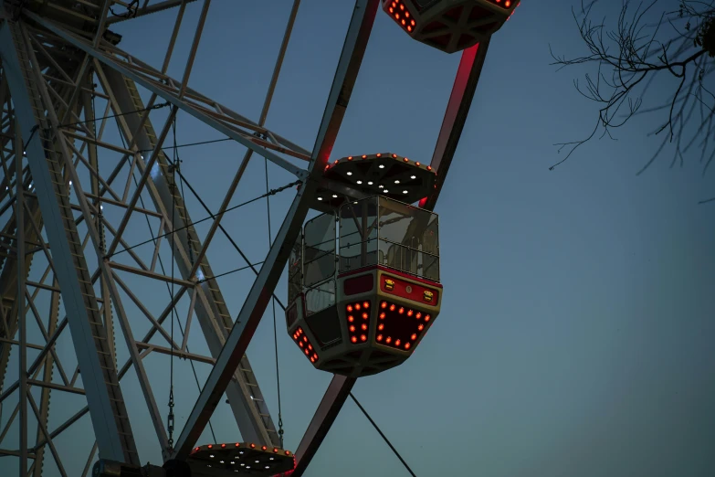 the carnival ferris wheel is lit red and orange