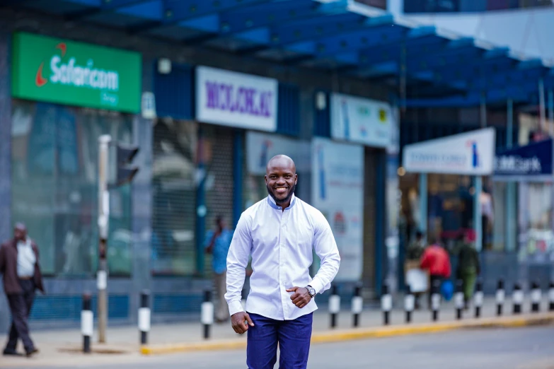 the man is wearing pants and a white shirt and crossing the street