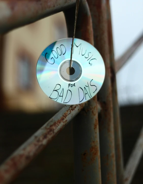 a cd on the back of a rusty steel fence