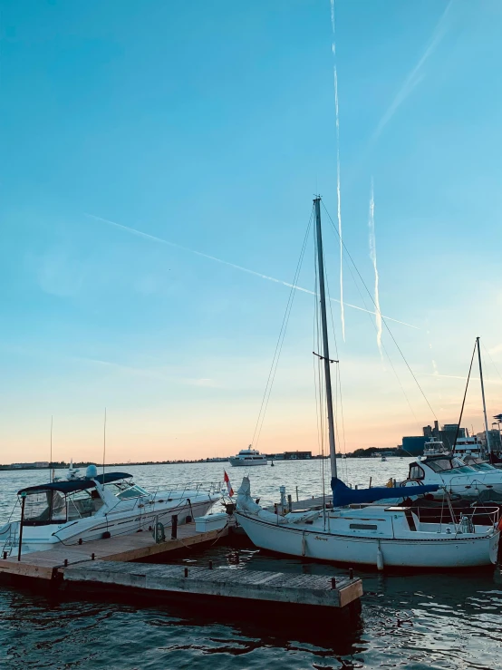 sailboats are moored at a pier on the ocean