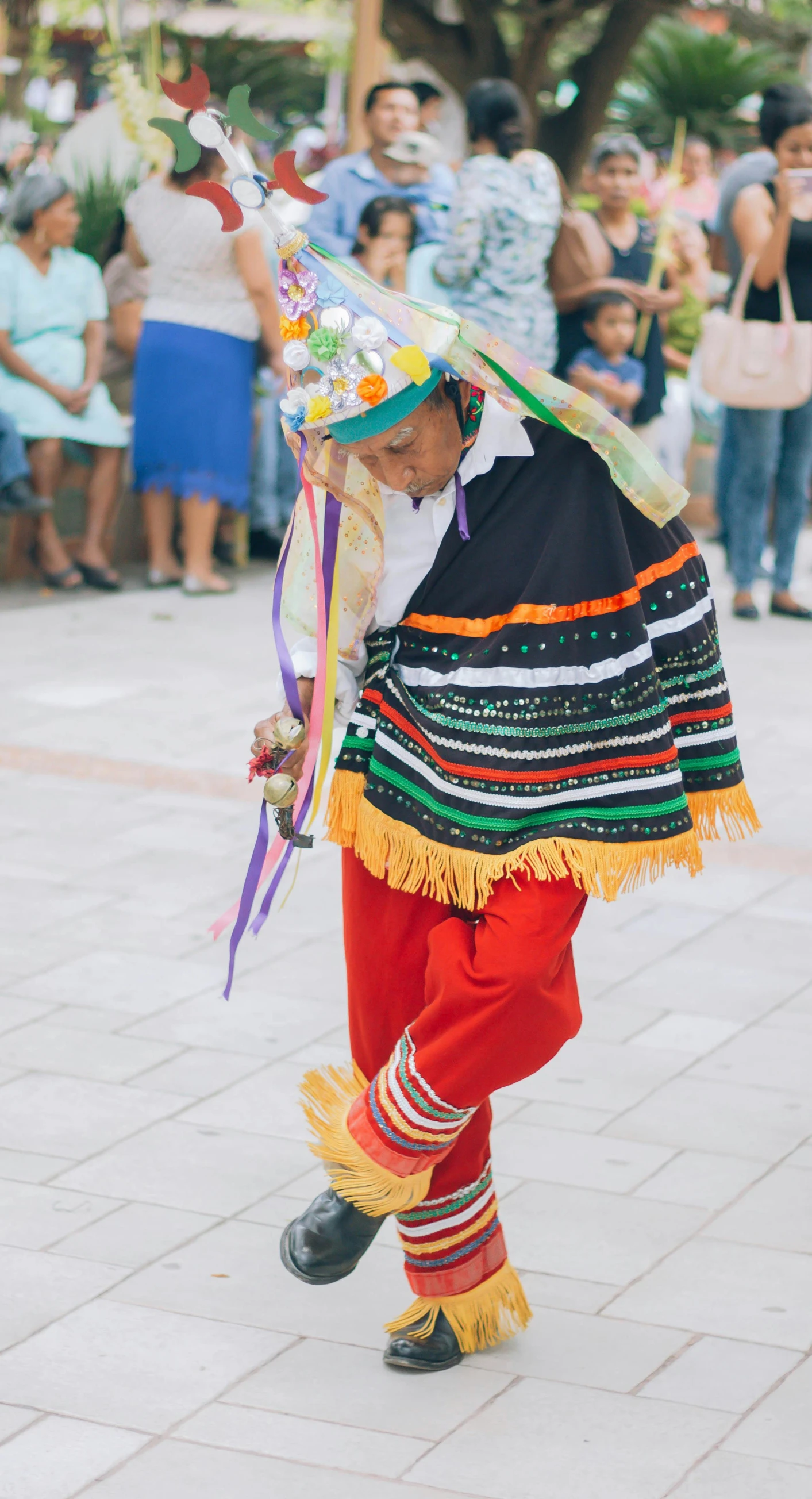 a child in native clothing, with people in the background