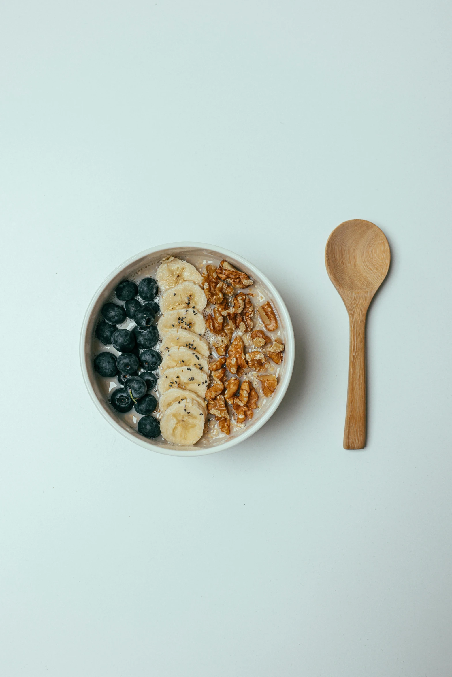 a bowl of cereal, banana, blueberries and almonds