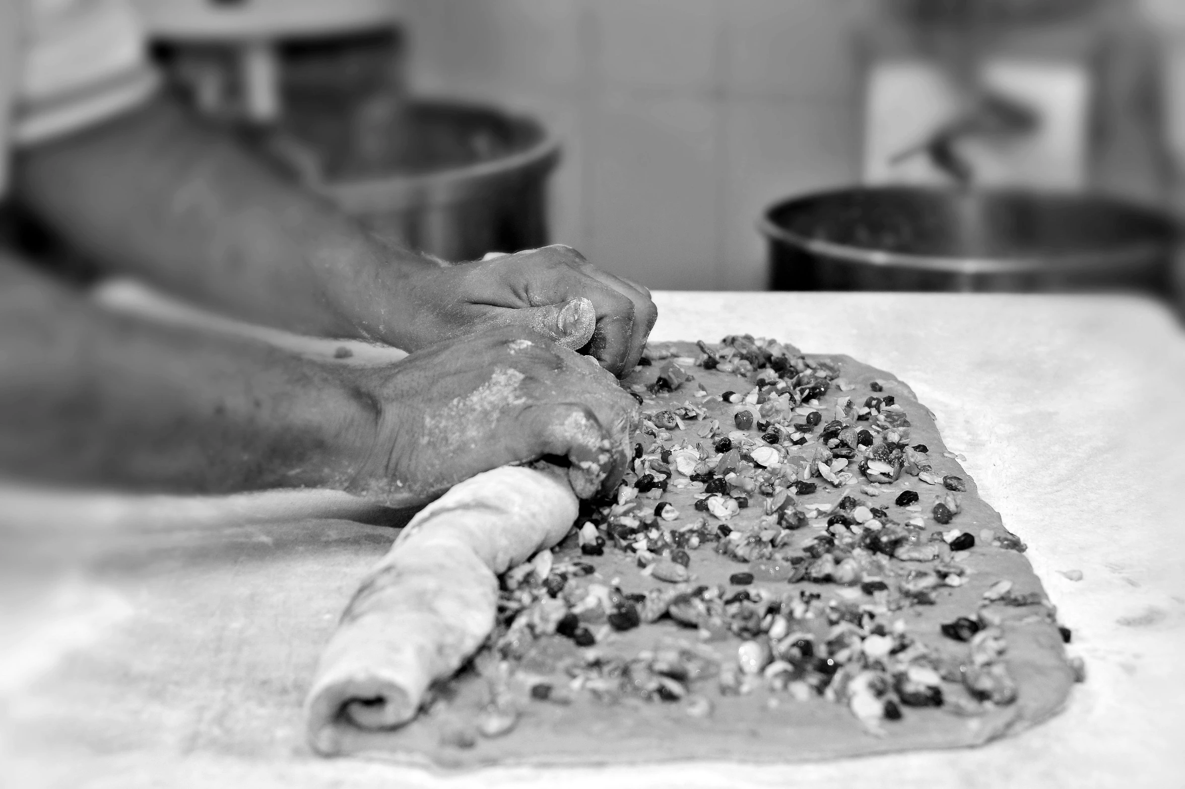 person making a doughnut shaped pizza on top of a table