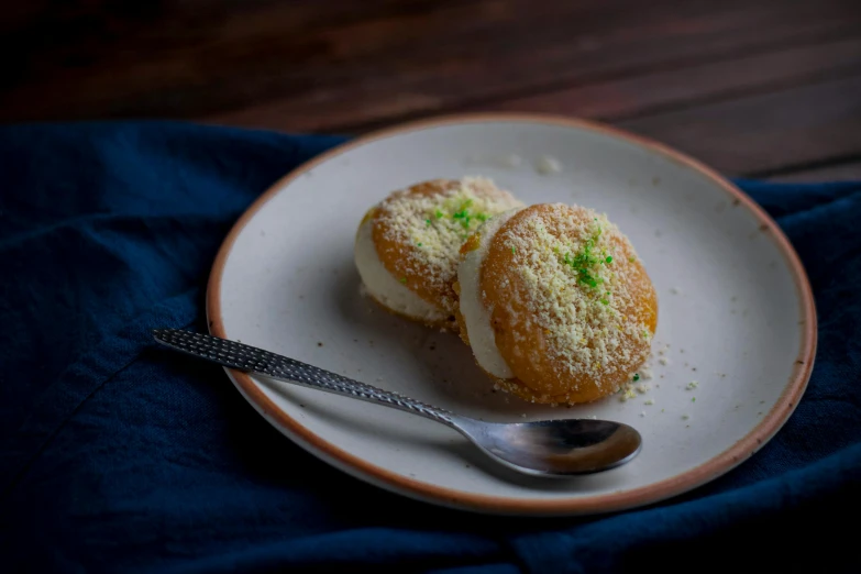 two pastries on plate on top of a blue cloth