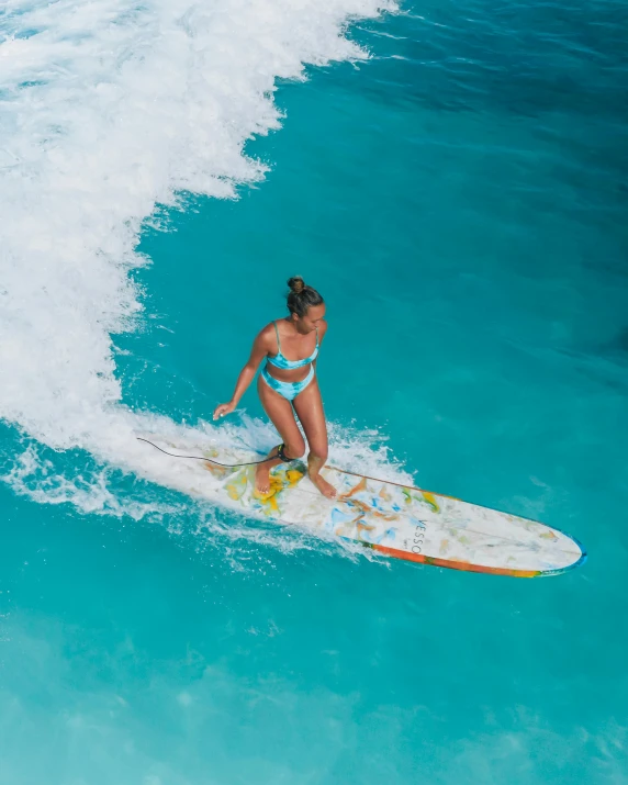 a woman is on a surf board riding a wave