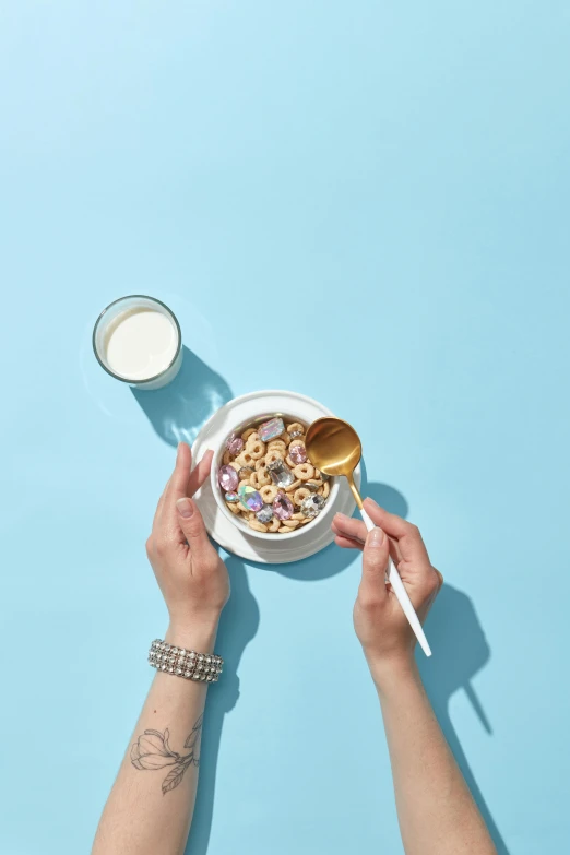 a person holding a spoon above a bowl of cereal