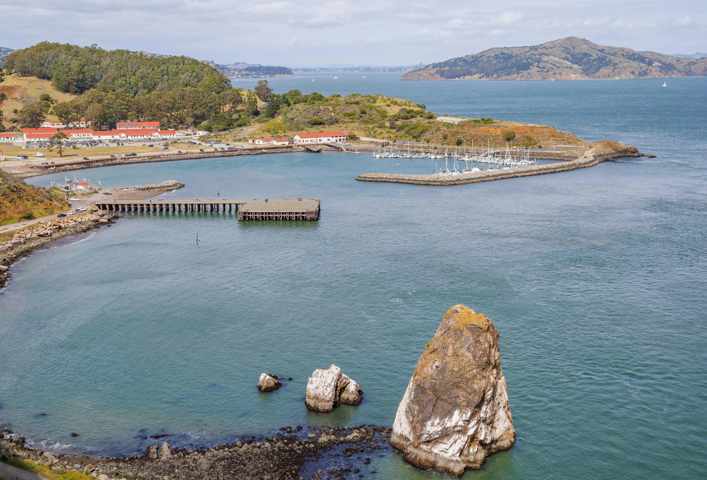 small boat dock on a bay surrounded by mountains