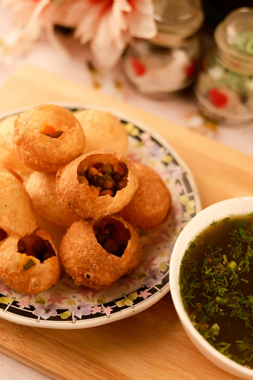 there are several small desserts on a plate with a bowl of green sauce