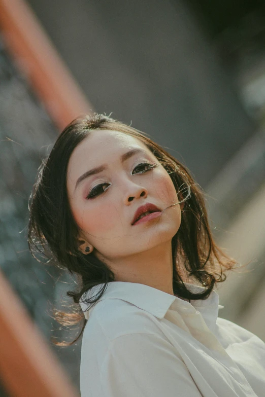 a woman with dark hair wearing a white shirt