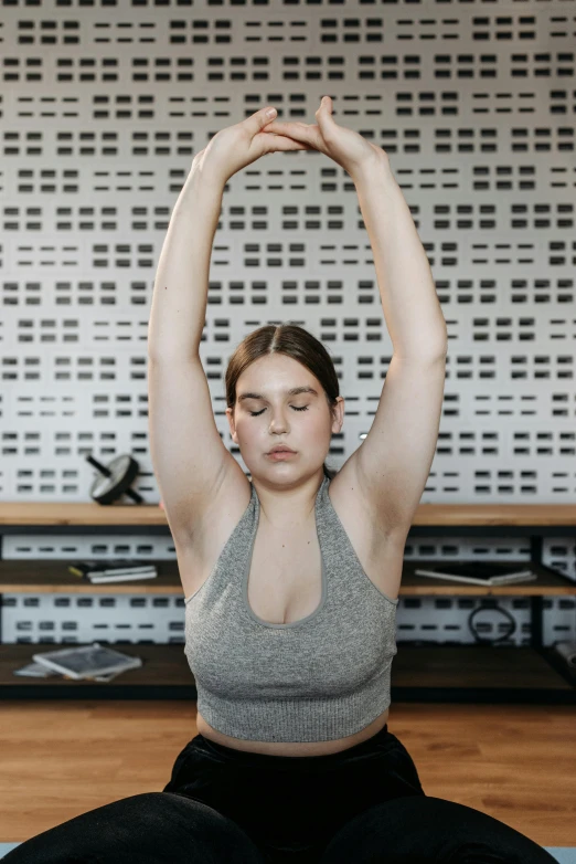 a woman doing yoga with her hands in the air