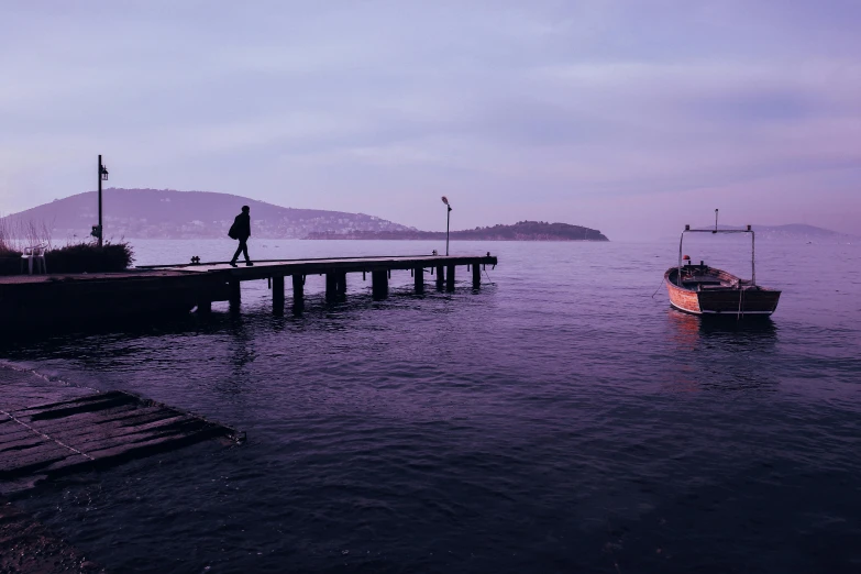 people standing on the dock watching boats