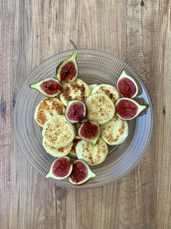 a plate of cut fig fruit on top of a wooden table
