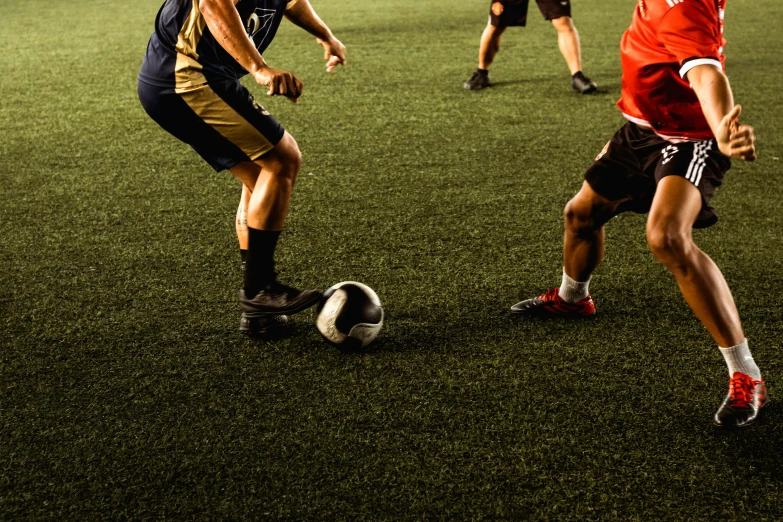 a group of men are playing soccer on an artificial field