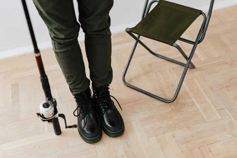 a person with their feet on a folding chair and an umbrella