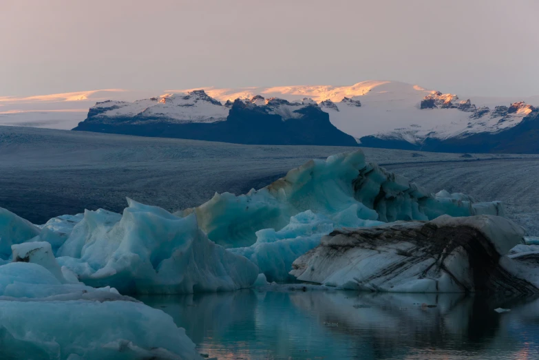 ice covered mountains, lake and snow covered ground