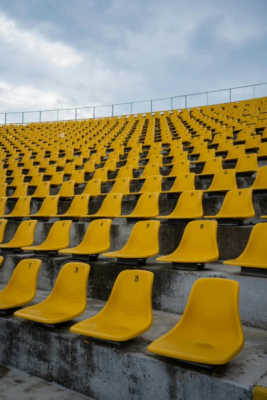 an empty yellow stadium with seats and dirt stairs