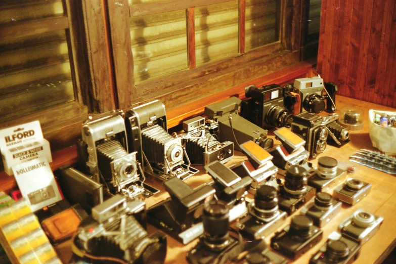 a wooden table with cameras, a camera, and other items