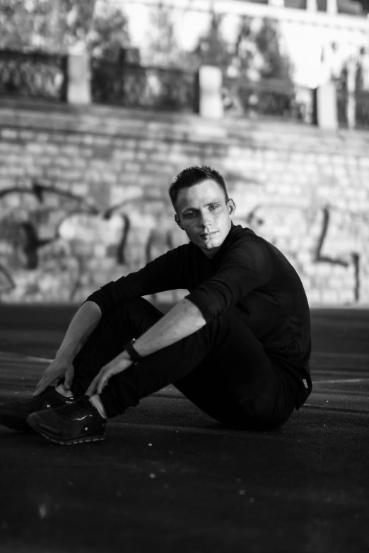 a man sitting on the ground in a black and white po